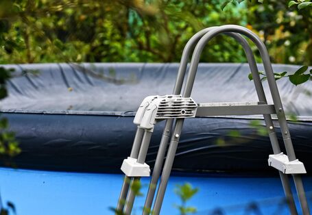 Abgedeckter Pool und Leiter im Vordergrund