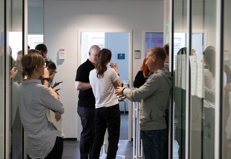 Viele Personen tauschen sich im Gespräch zu Themen der Künstlichen Intelligenz und Daten aus.