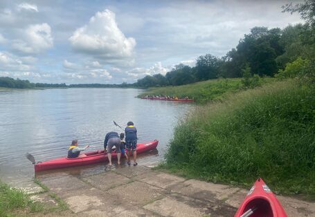 Teilnehmende der UBAwegs Tour im Mai steigen für die Paddeltour in ein Boot ein