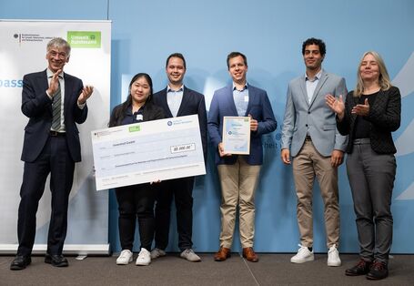 Stefan Tidow und Dr. Bettina Rechenberg überreichen einen Scheck an die Gewinner des Unternehmens inventied GmbH.