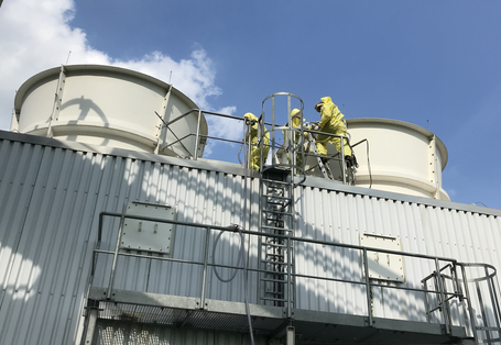 Menschen entnehmen Proben von einem Kühlturm.