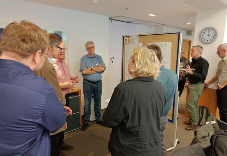 A group of people standing in a circle having a discussion