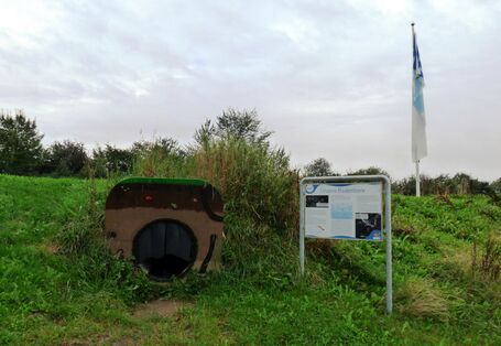 Foto einer Infotafel und des Kriechtunnels des Lehrpfades