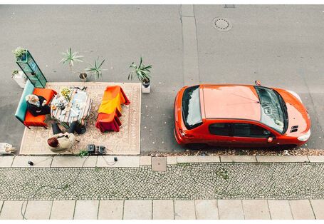 Hinter parkendem Fahrzeug wurde Wohnzimmer auf Parkplatz eingerichtet