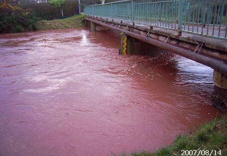 Foto: Sehr hoher Wasserstand der Helme an einer Brücke in Sundhausen, der fast die gesamte lichte Höhe der Brücke einnimmt. 