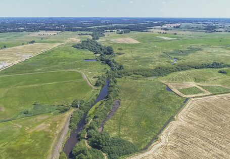 Luftbild der Wümme mit durchgehendem Gehölzsaum umgeben von landwirtschaftlich genutzten Grünlandflächen