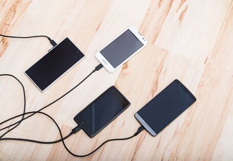 Smartphones hängen an Ladekabeln
