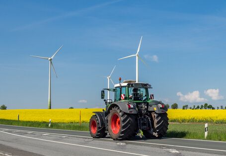 Ein Traktor vor einem Rapsfeld