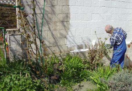 Ein Mann streicht eine Wand mit Schutzmitteln