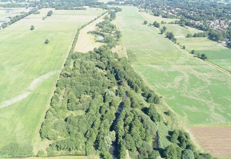 Luftbildaufnahme des sehr breiten Entwicklungskorridors mit Bäumen und Sträuchern, der den Fluss Wümme von landwirtschaftlichen Flächen und Grünland abgrenzt.
