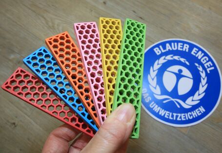 Bioblo-bausteine vor einem Logo des Blauen Engel
