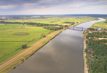 Der Fluss aus der Luft, dahinter Wiesen.