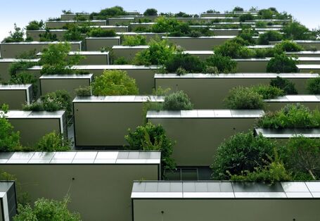 Hochhaus mit Begrünung durch Balkonpflanzen.