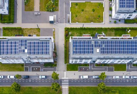 Luftbild eines Stadtquartiers mit Grünanlagen und Solarpanelen auf den Dächern.