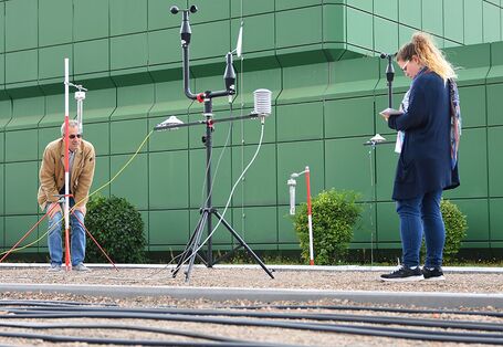 Ein Mann und eine Frau stehen auf einem Dach mit Messgeräten.