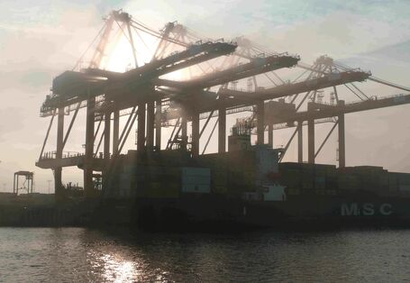 Hafenblick Bremerhaven mit Containerkran und Containerschiff.