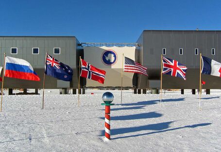 Am Südpol wehen die Flaggen der Erstunterzeichnerstaaten des Antarktis-Vertrages vor der amerikanischen Scott-Amundsen-Station.