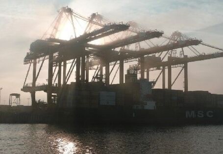 Port view of Bremerhaven with container crane and container ship.