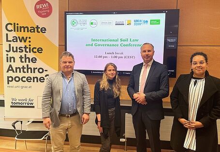 4 people standing in front of a video conferencing device.