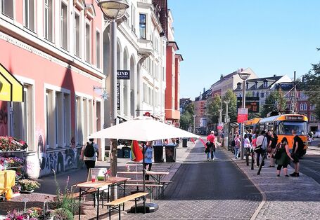 Ansicht des Lindenauer Markts ohne Autos. Es ist eine Straßenbahn und eine leere Straße zu sehen.