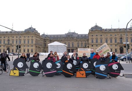 Teilnehmende stehen hinter den Maskottchen, die sie getragen haben.