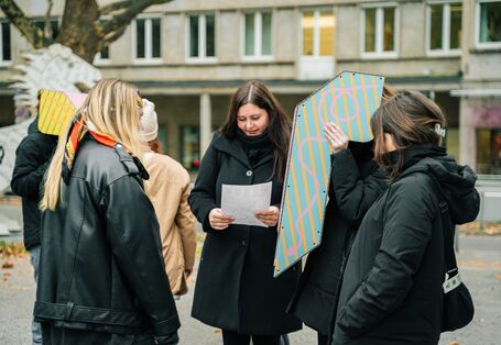 Teilnehmer*innen probieren das Tief-Seh-Rohr aus