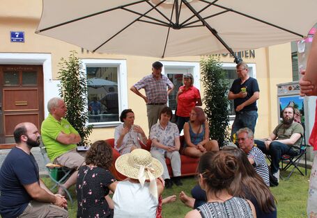 Bürgerinnen und Bürger treffen sich auf einem Parkplatz zum Dialog