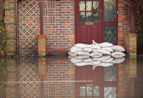 Sandsäcke wurden vor einer Haustür aufgestapelt, um das Haus vor Hochwasser zu schützen