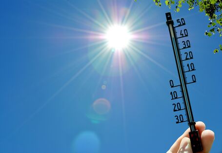 Bei starker Sonnenstrahlung sind auf einem Thermometer hohe Temperaturen zu erkennen.