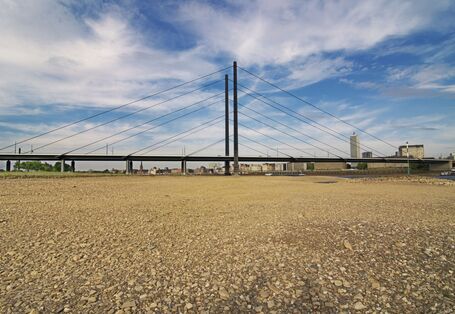 Eine Autobrücke führt über einen teils ausgetrockneten Fluß.