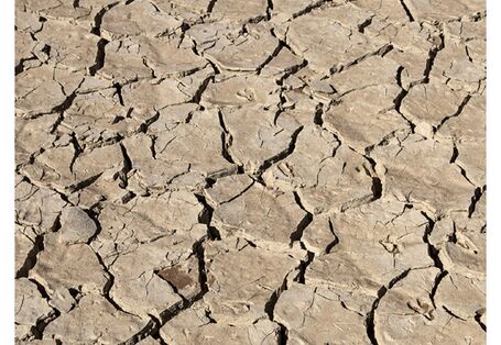 Cover von "Anpassung an den Klimawandel: Boden" mit einem Foto eines ausgetrockneten, rissigen Bodens