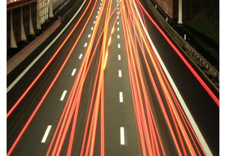 Cover von "Anpassung an den Klimawandel: Verkehr" mit einem Foto einer Autobahn bei Nacht