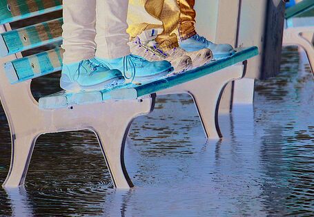 People standing on a seat bench surrounded by water
