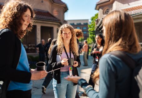Mehrere Personen unterhalten sich im Außenbereich des Veranstaltungsorts.