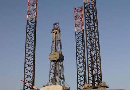 Das Foto zeigt eine Installationsplattform (oder JackUp barge) zum Bau von Offshore-Windparks im Hafen. Die Installationsplattform hat drei „Beine“ mit denen sie aufgeständert werden kann um die großen Windenergieanlagen zu installieren.