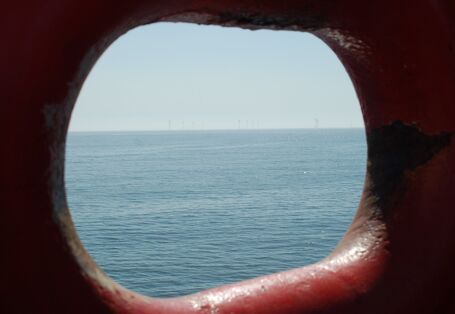 Das Foto zeigt in der Ferne die 12 Windenergieanlagen des Offshore Windparks Alpha Ventus.