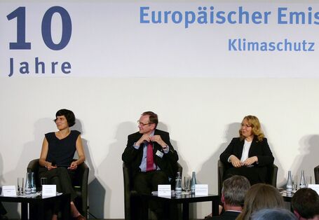 drei Frauen und zwei Männer sitzen auf einem Podium und diskutieren. Auf einem Banner darüber steht "10 Jahre Europäischer Emissionshandel"
