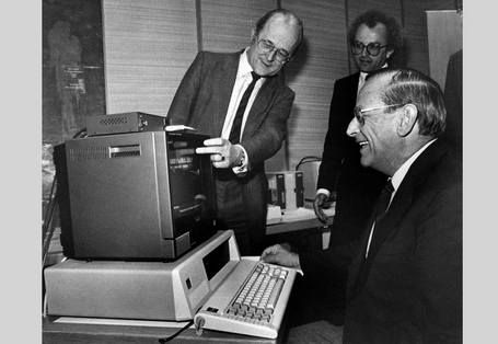 UBA-Präsident von Lersner zeigt anderen das Angebot "Bildschirmtext" an einem Monitor