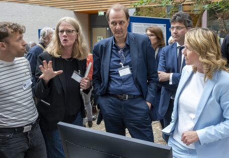 Steffi Lemke und andere an einem Stand mit einem Monitor
