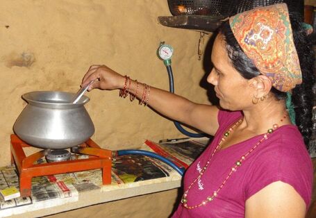 eine Frau in Nepal kocht zuhause auf einem kleinen Gaskocher