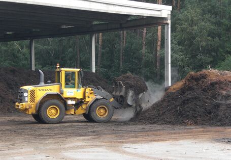 ein Radlader setzt einen großen Haufen Kompost um