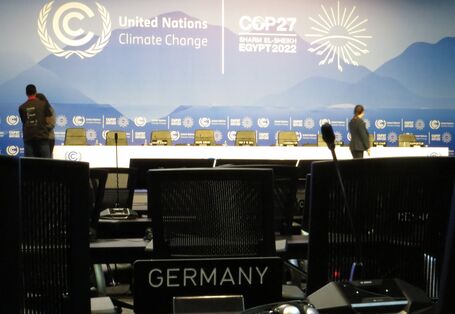 Saal mit Sitzreihen auf der COP27, auf einem Platz steht ein Schild "Germany", ein Mikrofon und ein Kopfhörer