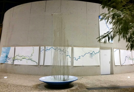 Kunstinstallation im Vorraum des UBA Dessau: über einer großen Schale hängt ein Vorhang aus Schnüren, an dem Wasser herunterläuft, man erkennt die Silhouette eines Menschen