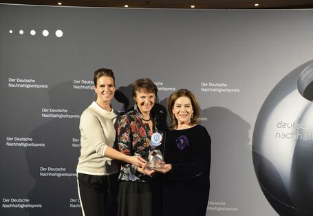 three women holding a Blue Angel Award thophy