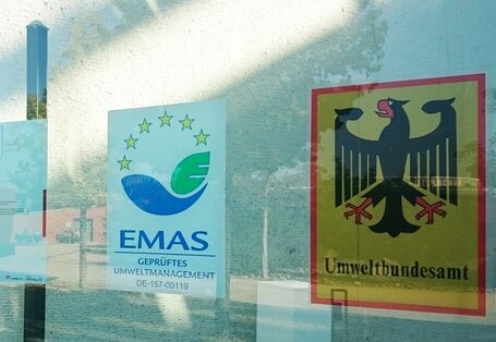 EMAS-Logo an der Glasfassade des Haupteingangs des UBA Dessau-Roßlau
