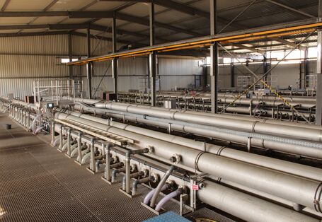 Halle mit einem System dicker Rohre und einem Metallgitterboden