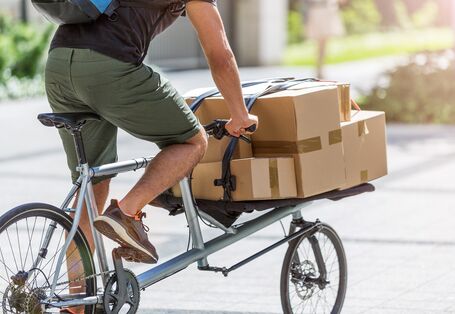 ein Fahrradkurier transportiert Pakete und Päckchen auf einem Lastenrad