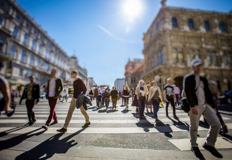 Fußgängerinnen und Fußgänger auf einem breiten Zebrastreifen in der Sadt