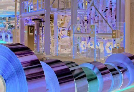 in einer Fabrikhalle liegen mehrere Rollen mit aufgerollten Messingbändern