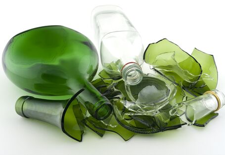 teilweise zerbrochene grüne und weiße Glasflaschen